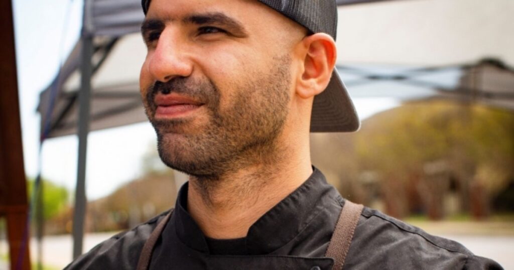 A man in a hat and black shirt, representing Barbecue Showdown contestants, stands confidently in a vibrant setting