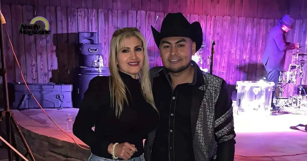 A man and woman, Jose Torres and his wife, smiling together for a photo at a lively concert.